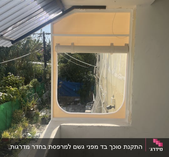 סוכך מתכת מעל חלון עם צל חלקי